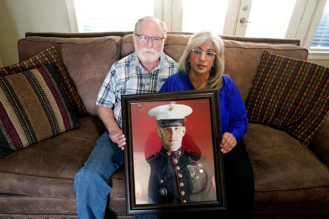 FILE - Joey and Paula Reed pose for a photo with a portrait of their son, Marine veteran and Russian prisoner Trevor Reed, at their home near Fort Worth, Texas, on Feb. 15, 2022. Russia is holding Trevor Reed, who was sentenced to nine years on charges he assaulted a police officer. The already-challenging path to bringing home Americans jailed in Russia and Ukraine is likely even more complicated now with a war overwhelming the region and increasingly hostile relations between the United States and the Kremlin. Marine veteran Trevor Reed and corporate security executive Paul Whelan are each serving long prison sentences in Russia.