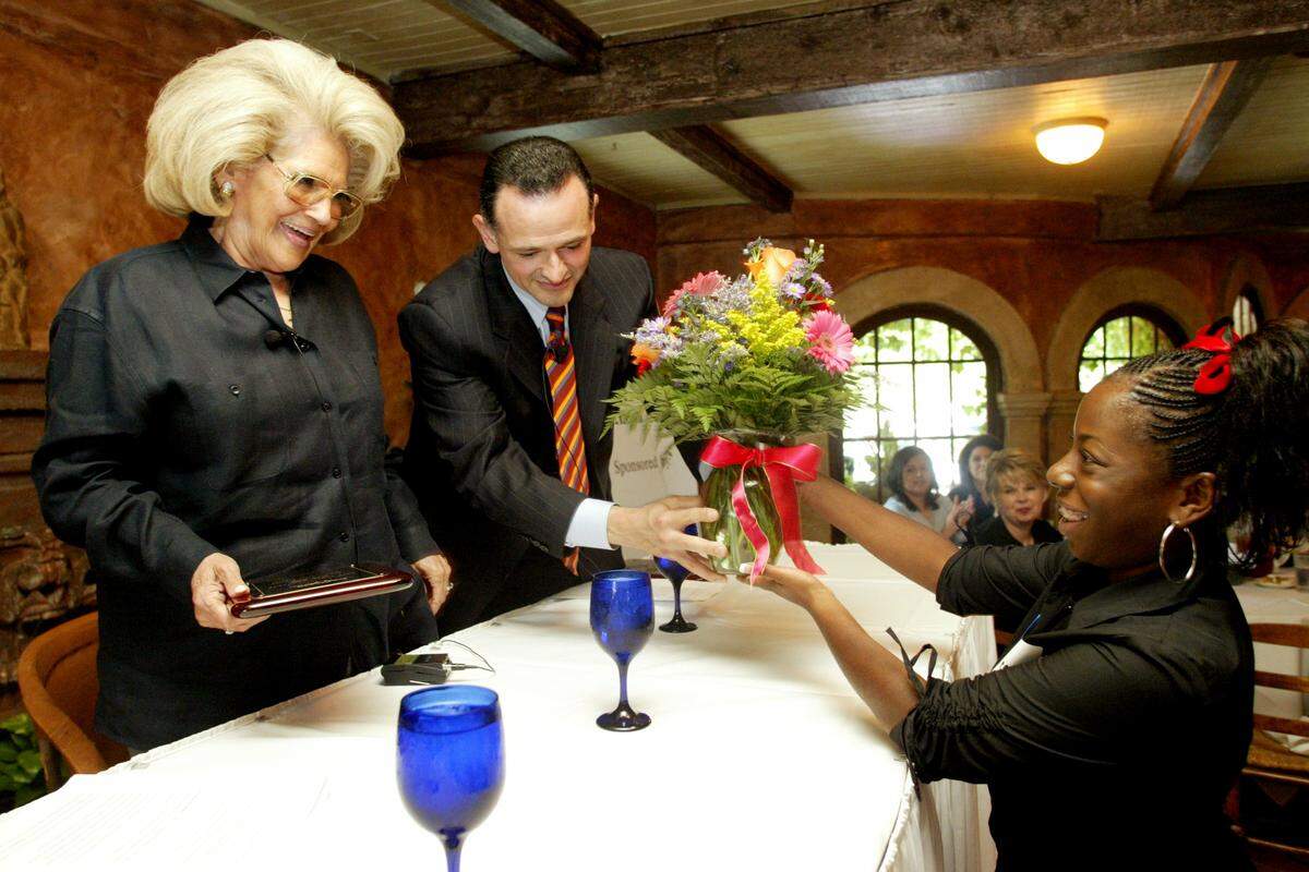 Aug. 26, 2003: Joe Lancarte, center, son of Hope Garcia Lancarte, left, receives a floral arrangement from VaNita Kincade, 16, of O.D. Wyatt for his mother during the first Women in Business luncheon. The luncheon was hosted by the Fort Worth Chamber of Commerce at Joe T. Garcia's Restaurant in Fort Worth. Hope Garcia Lancarte was interviewed at the event that included at-risk teen girls from local high schools O. D. Wyatt, Paschal and North Side. The luncheon is a part of the Chamber's Stay-in-school initiative.