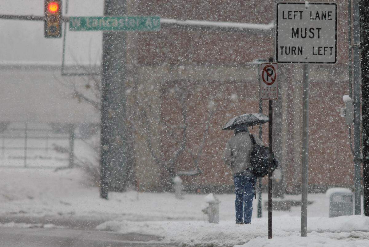 A pedestrian walks south of downtown as snow continues to fall, Thursday February 11, 2010.