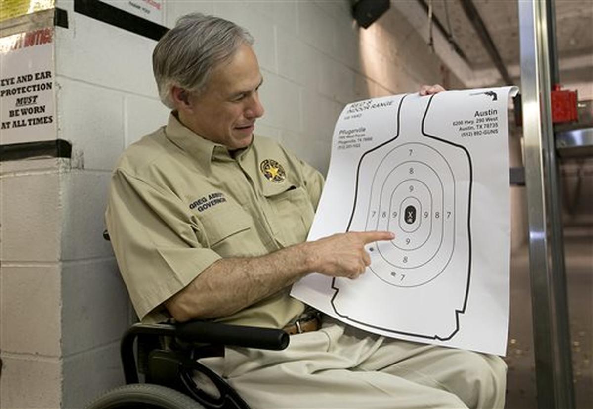 Texas Gov. Greg Abbott displays his marksmenship at Red’s Indoor Range in Pfulgerville, Texas, Saturday, June 13, 2015. Abbott stopped at the gun range to sign into law bills letting Texans carry concealed handguns on college campuses and openly carry them virtually everywhere else. (Ralph Barrera/Austin American-Statesman via AP) AUSTIN CHRONICLE OUT, COMMUNITY IMPACT OUT, INTERNET AND TV MUST CREDIT PHOTOGRAPHER AND STATESMAN.COM, MAGS OUT