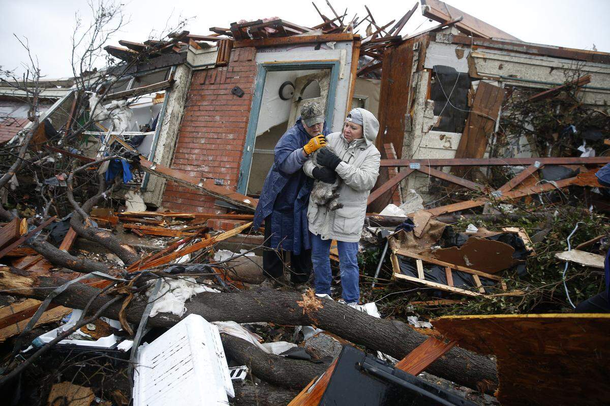 Pam Russell, left, and Linda Hart rescue Russell's cat Larue from the rubble of her house on Sunday, Dec. 27, 2015, a day after a tornado hit Delta Drive in Rowlett, east of Dallas.