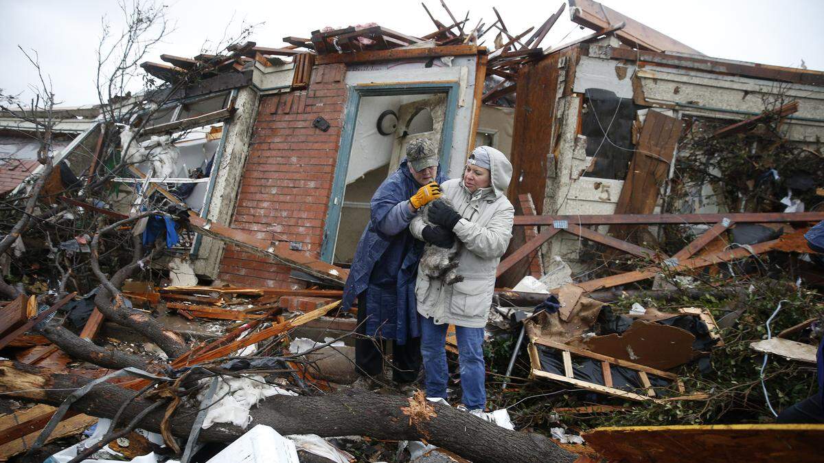 Pam Russell, left, and Linda Hart rescue Russell's cat Larue from the rubble of her house on Sunday, Dec. 27, 2015, a day after a tornado hit Delta Drive in Rowlett, east of Dallas.