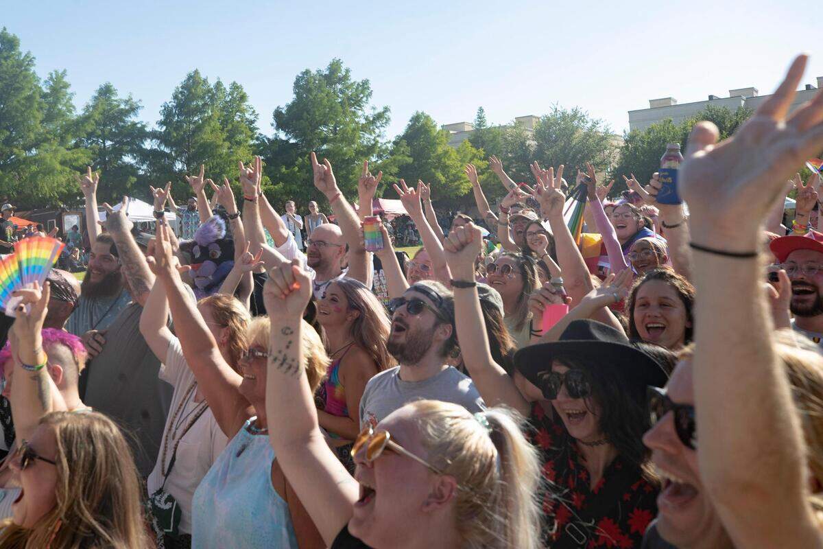 Attendants of Trinity Pride rally in front of the performers stage at Magnolia Green Park on Saturday, June 25, 2022.