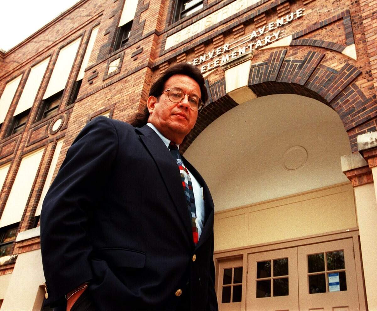 In this Dec. 3, 1998, photo, Rufino Mendoza Jr. stands before Denver Avenue Elementary School ahead of presenting a petition to the Fort Worth school district to rename the campus after his father, Rufino Mendoza Sr.