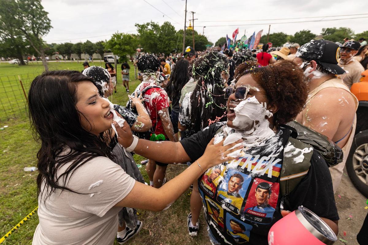Festival attendees cover each other in shaving cream during the Lao New Year parade on the third day of the Lao New Year festival at Wat Lao Thepnimith Temple in Saginaw on Sunday, April 27, 2025.