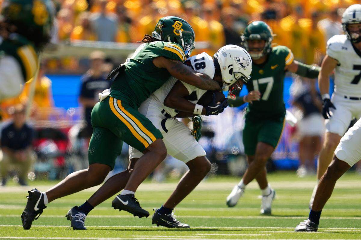 Sep 13, 2025; Waco, Texas, USA; Samford Bulldogs wide receiver Torrey Ward (18) is tackled by Baylor Bears linebacker Keaton Thomas (11) during the first half at McLane Stadium. Mandatory Credit: Chris Jones-Imagn Images