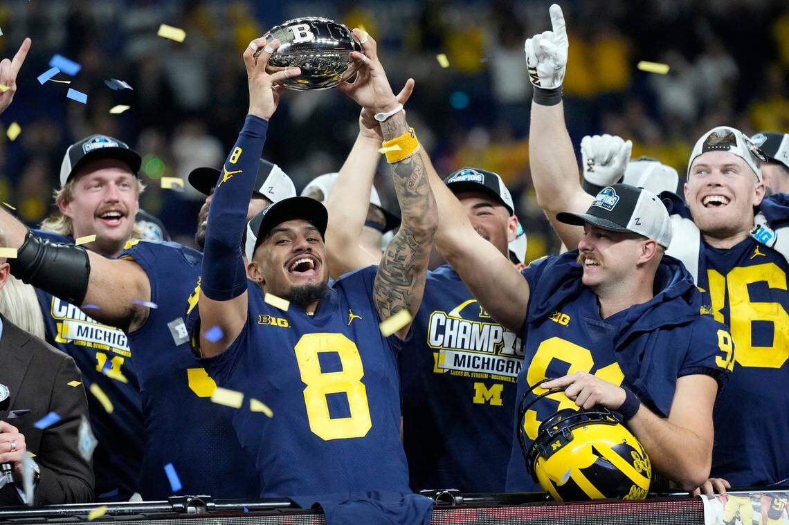 Michigan wide receiver Ronnie Bell holds the trophy as he celebrates with teammates after defeating Purdue in the Big Ten championship on Dec. 4 in Indianapolis.