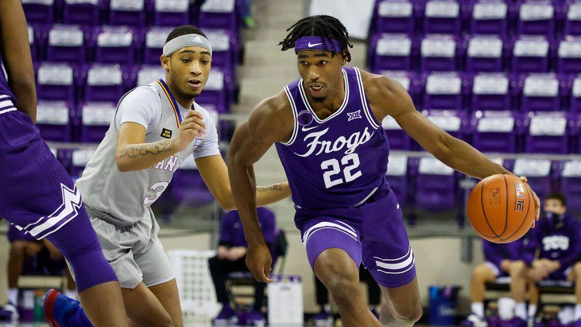 TCU’s RJ Nembhard (22, right) drives against Kansas’ Dajuan Harris on Tuesday night at Schollmaier Arena.