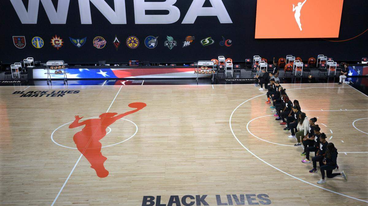 FILE - In this Aug. 30, 2020, file photo, members of the Connecticut Sun team kneel during the playing of the national anthem before a WNBA basketball game against the Washington Mystics, in Bradenton, Fla. Ahead of Labor Day, major U.S. labor unions say they are considering work stoppages in support of the Black Lives Matter movement. The unions say they’re following the lead of professional athletes who last week staged strikes to protest the shooting of Jacob Blake in Kenosha, Wis. (AP Photo/Phelan M. Ebenhack, File)