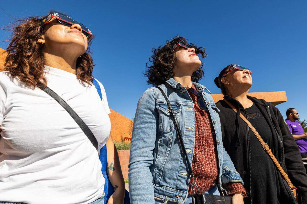 Jennifer and Jessica Elizalde look up at the solar eclipse with their mother Mary Elizalde during the Annular Solar Eclipse event at the Fort Worth Museum of Science & History on Saturday, Oct. 14, 2023.