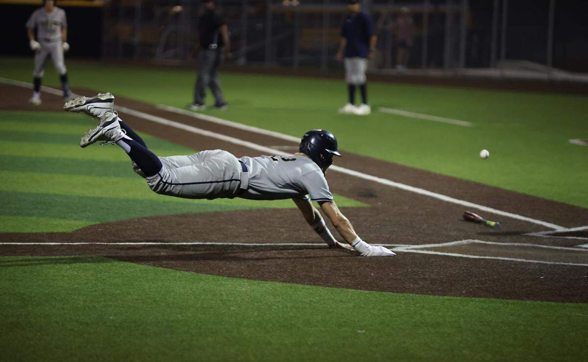 Keller’s Brock Burkett dives in to home just in front of the tag on a two-run single by Bach Hartwig against Hebron in Game 2 of their Class 6A Division 1 regional semifinal on Friday, May 16, 2025 at the Coppell Baseball/Softball Complex in Coppell, Texas. Keller defeated Hebron 7-1 to sweep the series.