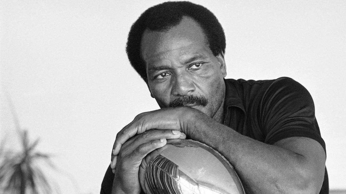 FILE - Jim Brown, who set the National Football League rushing record of 12,312 yards while playing for the Cleveland Browns, sits pensively in his home, Tuesday, Sept. 19, 1984, Los Angeles, Calif. NFL legend, actor and social activist Jim Brown passed away peacefully in his Los Angeles home on Thursday night, May 18, 2023, with his wife, Monique, by his side, according to a spokeswoman for Brown’s family. He was 87. (AP Photo/Lennox McLendon, File)