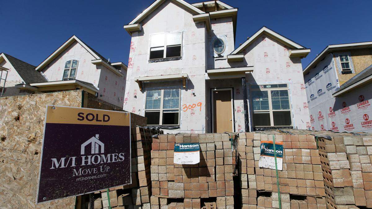 A “sold” sign in front of a not yet completed new built home in Plano, TX. 