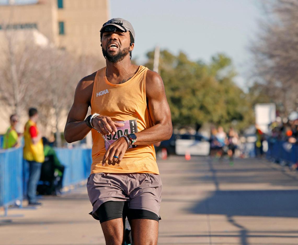 Tamar Hicks crosses the finish line in hand cuffs during the 46th annual Cowtown Marathon at Will Rogers Complex in Fort Worth, Texas, Sunday, Feb. 25, 2024. Hicks was attempting to break the Guiness record for half marathon time ran in handcufs. He completed the race with a chip time of 01:20:36 and a gun time of 01:29:47. More than 10,000 runners registered for the race. (Special to the Star-Telegram Bob Booth)