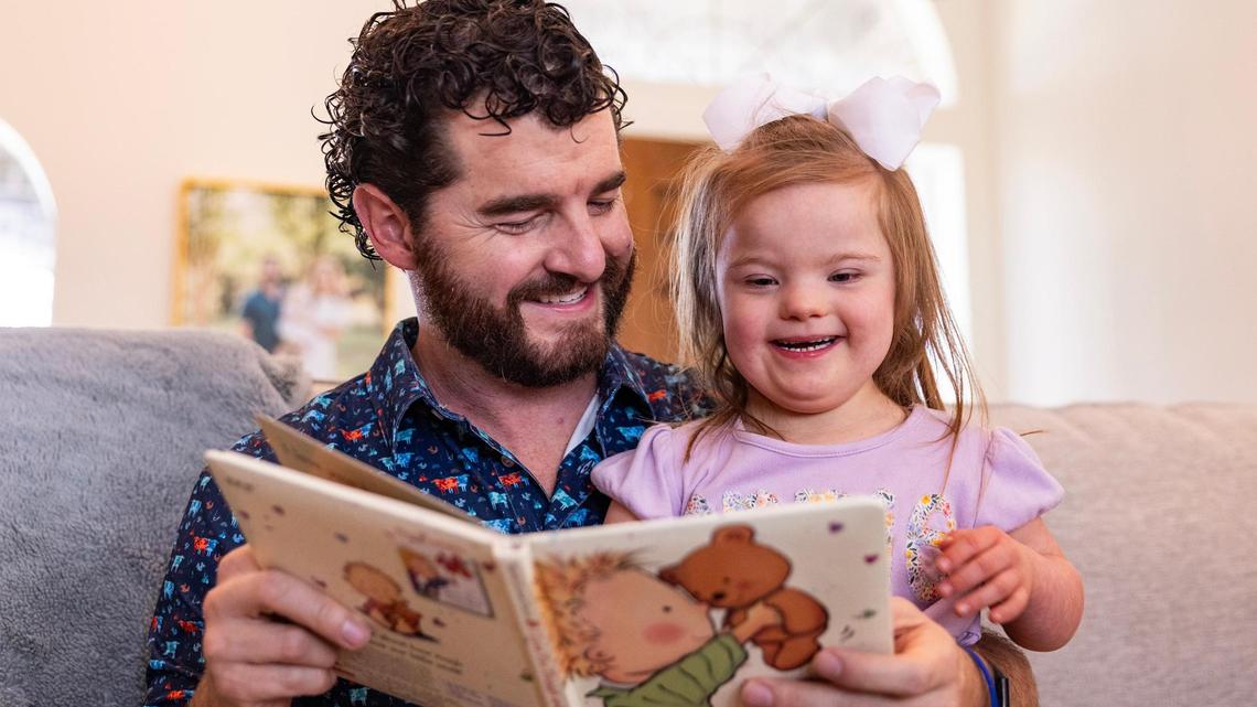 Annie Morey, 4, shares a laugh with her father, Spencer, while reading a book in the living room of their home northwest of Fort Worth on Friday, March 28. The Morey family has been in a legal battle with Aledo ISD because they oppose an IQ test for Annie, who has Down syndrome, fearing it could limit her potential in school.