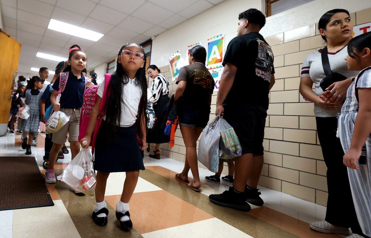 Students arrive at M.H. Moore Elementary School for the first day of school on Tuesday.