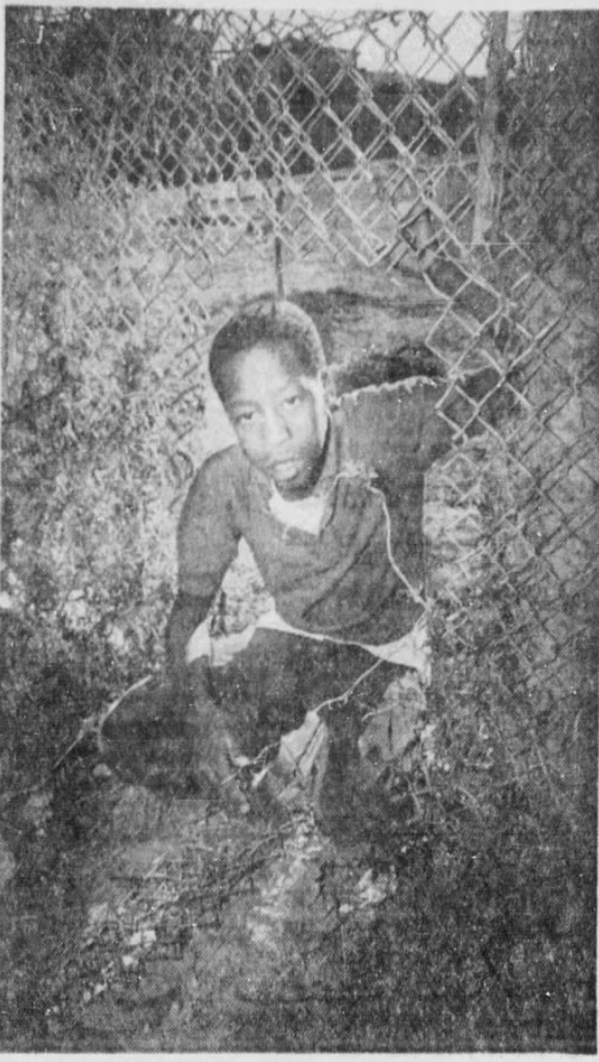 Eleven-year-old Willie Morris climbs through a hole in the fence portion of the “Ridglea Wall” on March 26, 1969.