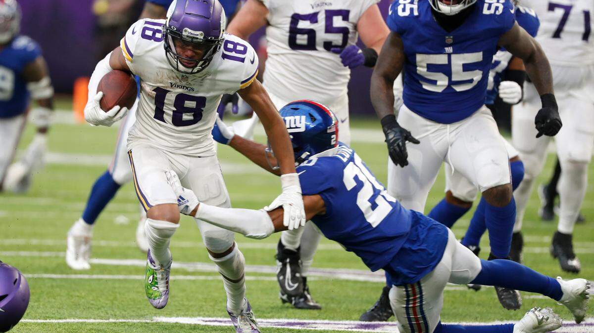 Minnesota Vikings wide receiver Justin Jefferson (18) runs from New York Giants safety Julian Love (20) after catching a pass during the second half of an NFL football game, Saturday, Dec. 24, 2022, in Minneapolis.