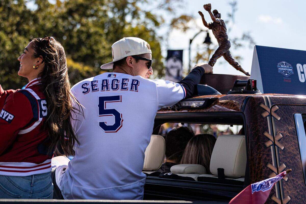 Rangers shortstop Corey Seager rides into the parade with his World Series MVP Trophy for the World Series Parade in front of Globe Life Field in Arlington on Friday, Nov. 3, 2023.