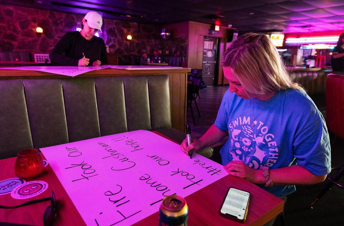 Hayley Schmolze, right, and Lauren Garcia, both residents of The Cooper apartments in Fort Worth, make signs at the Down n’Out bar while preparing to protest the management and owners of The Cooper on July 7. 