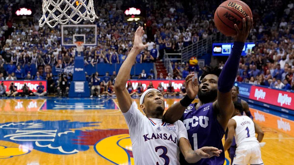 TCU guard Mike Miles (1) shoots under pressure from Kansas guard Dajuan Harris Jr. (3) during the second half of Thursday’s game in Lawrence. Miles missed a layup with the Frogs down three points in the waning seconds of a 72-68 loss. “I probably got fouled but we weren’t getting them all night,” Miles said.
