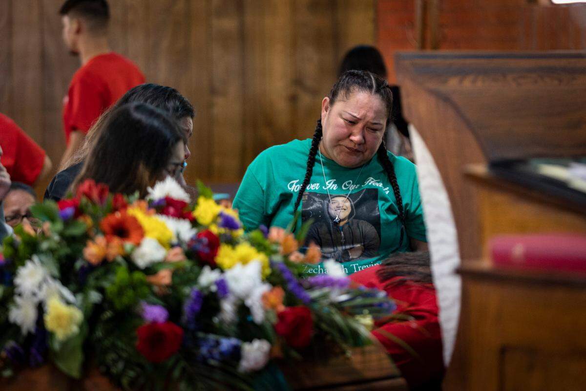 Erica Trevino stands beside her son’s casket during his funeral in Waurika, Oklahoma, on Jan. 28, 2023. Zechariah Trevino, killed by gun violence on Jan. 20, was remembered as a loving, funny person throughout the service.