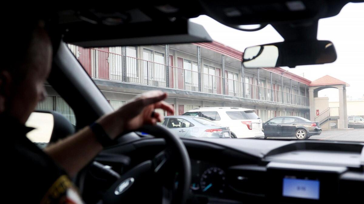 White Settlement police chief Christopher Cook drives a police car through the Red Roof Inn parking lot. A task force has been created to reduce crime at hotels and motels along Interstate 30 and West Loop 820 South.