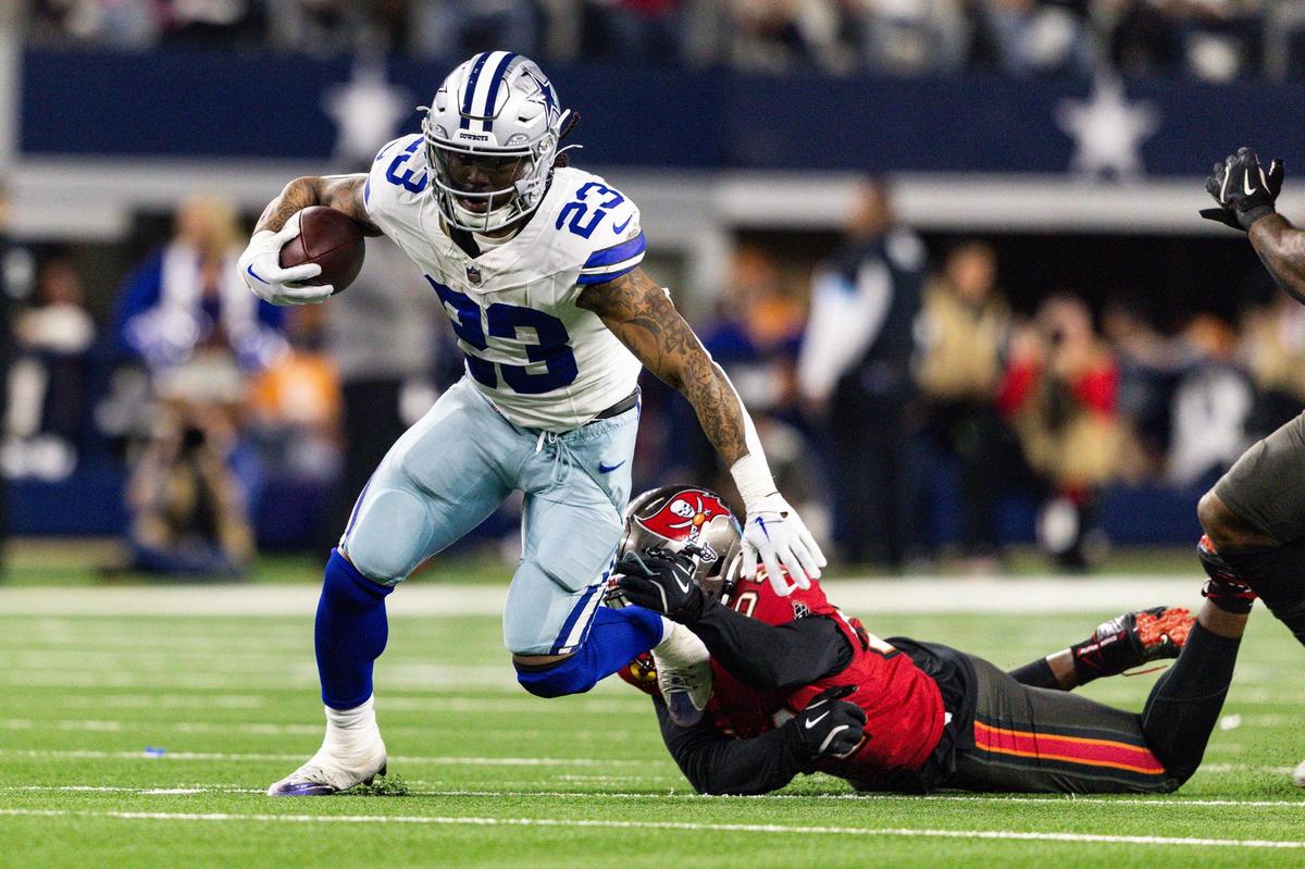 Cowboys running back Rico Dowdle (23) gets past a tackle in the first half of an NFL game between the Dallas Cowboys and the Tampa Bay Buccaneers at AT&T Stadium in Arlington on Sunday, Dec. 22, 2024.