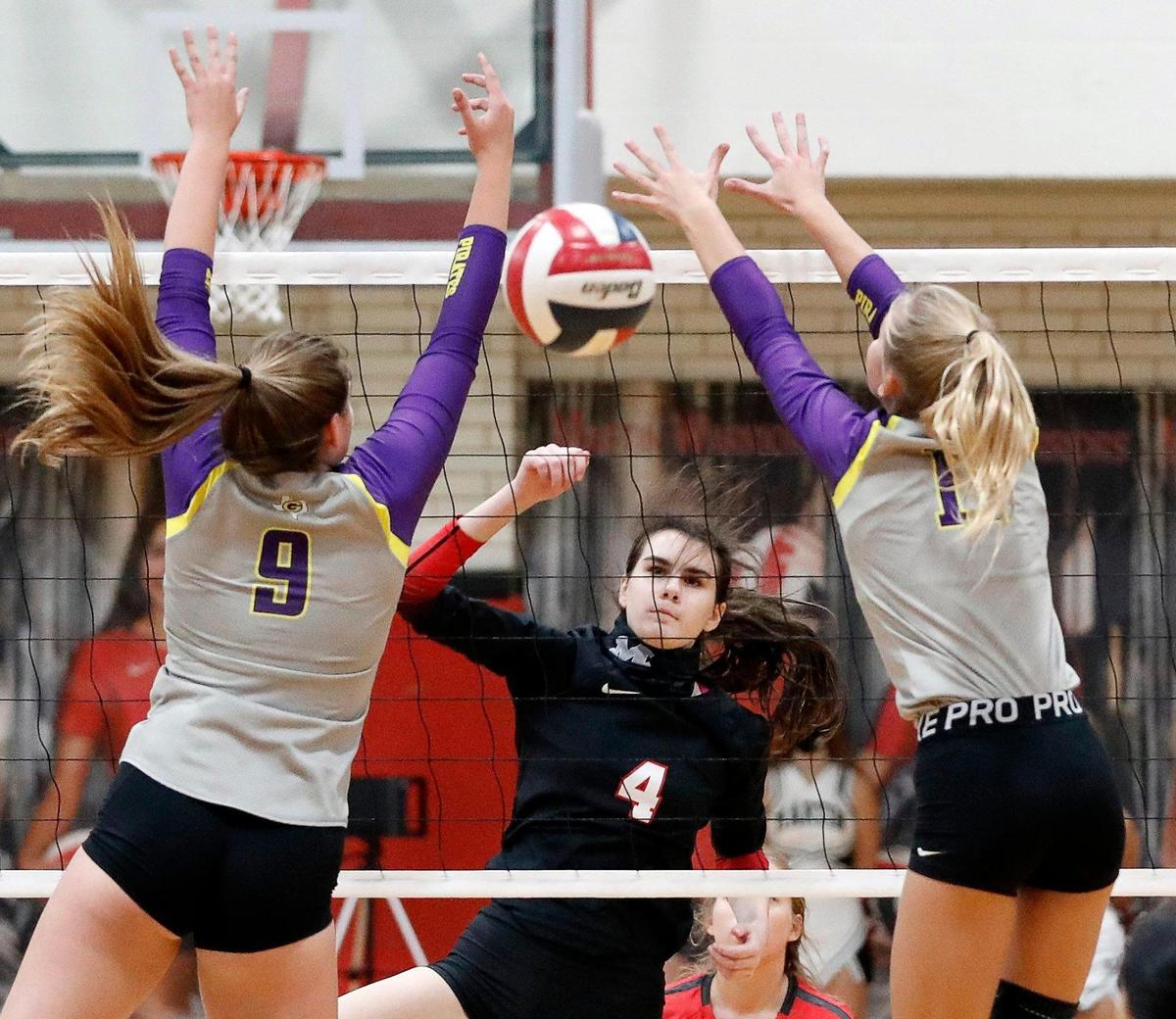 Martin’s Emily Adams slips a ball through the defense of Granbury’s Ellie Alexander and Kylie Hagan during a high school volleyball match at Martin High School in Arlington, Texas, Tuesday, Sept. 29, 2020. Martin Lady Warriors defeated the Granbury Lady Pirates in three straight sets. (Special to the Star-Telegram Bob Booth)