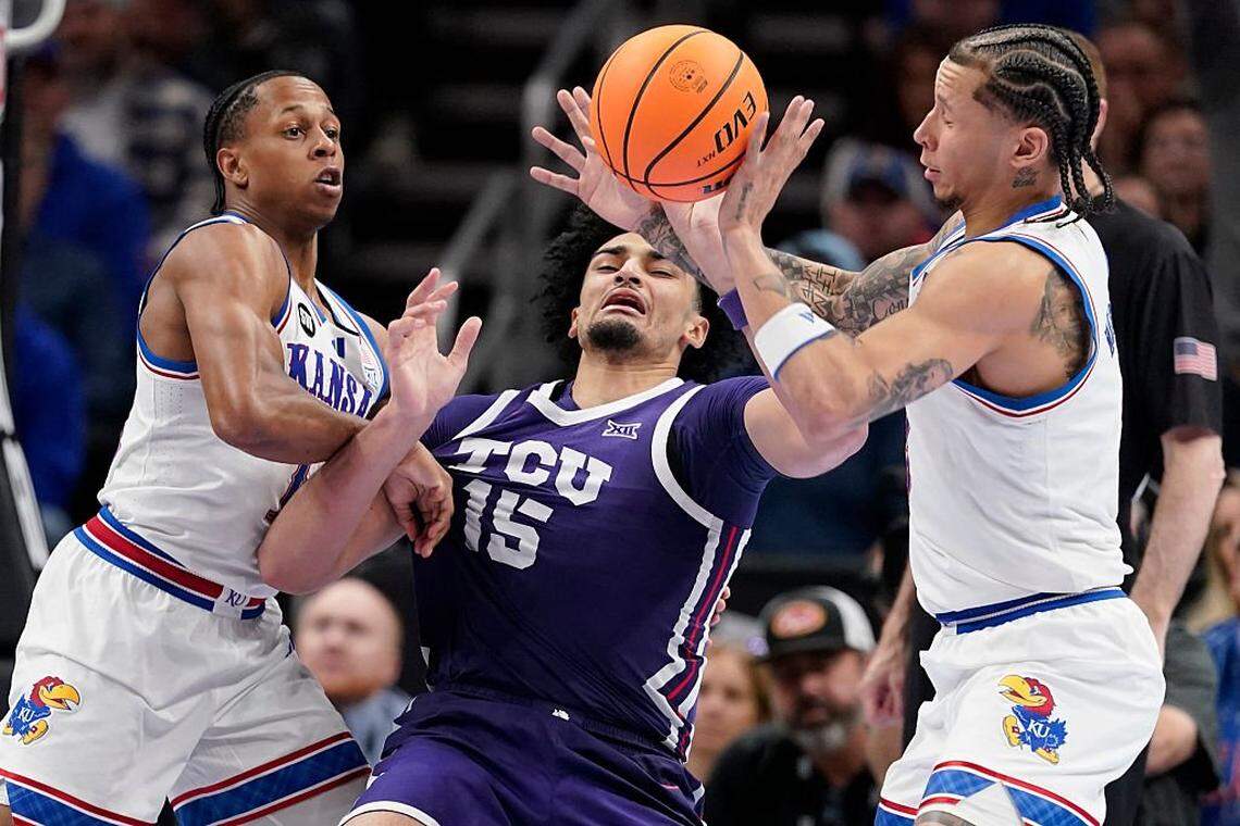 KANSAS CITY, MISSOURI - MARCH 12: David Punch #15 of the TCU Horned Frogs loose control of the ball against Elmarko Jackson #13 and Tre White #3 of the Kansas Jayhawks in the second half during the quarterfinals of the Big 12 Tournament at T-Mobile Center on March 12, 2026 in Kansas City, Missouri. (Photo by Ed Zurga/Getty Images)