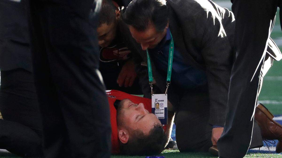 San Francisco 49ers defensive end Nick Bosa, bottom, is checked on by the team physician and trainers during the first half. Bosa missed the second half with a concussion.