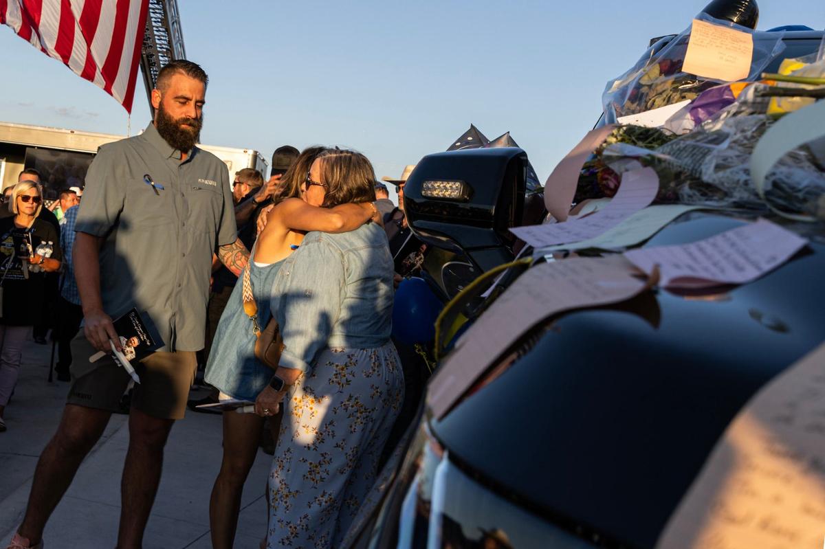 Family members of Fort Worth Police Department Sgt. Billy Randolph embrace after putting birthday cards on his patrol car in his memory during his honorary candlelit vigil at the Fort Worth PD South Division headquarters in Fort Worth on Wednesday, Aug. 14, 2024. Sgt. Randolph was struck by a vehicle while working a crash scene on the exit ramp of IH-35W near Sycamore School Road Monday morning.