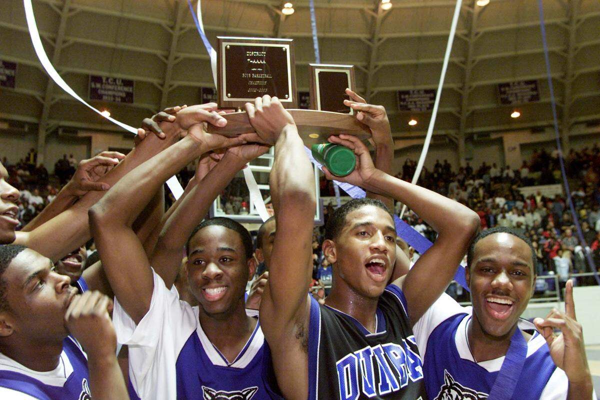 The Dunbar players celebrate winning the district championship as Dunbar’s coach Robert Hughes breaks the record as the all-time winningest basketball coach playing Polytechnic High School, Tuesday night at TCU’s Daniel Meyer Coliseum.