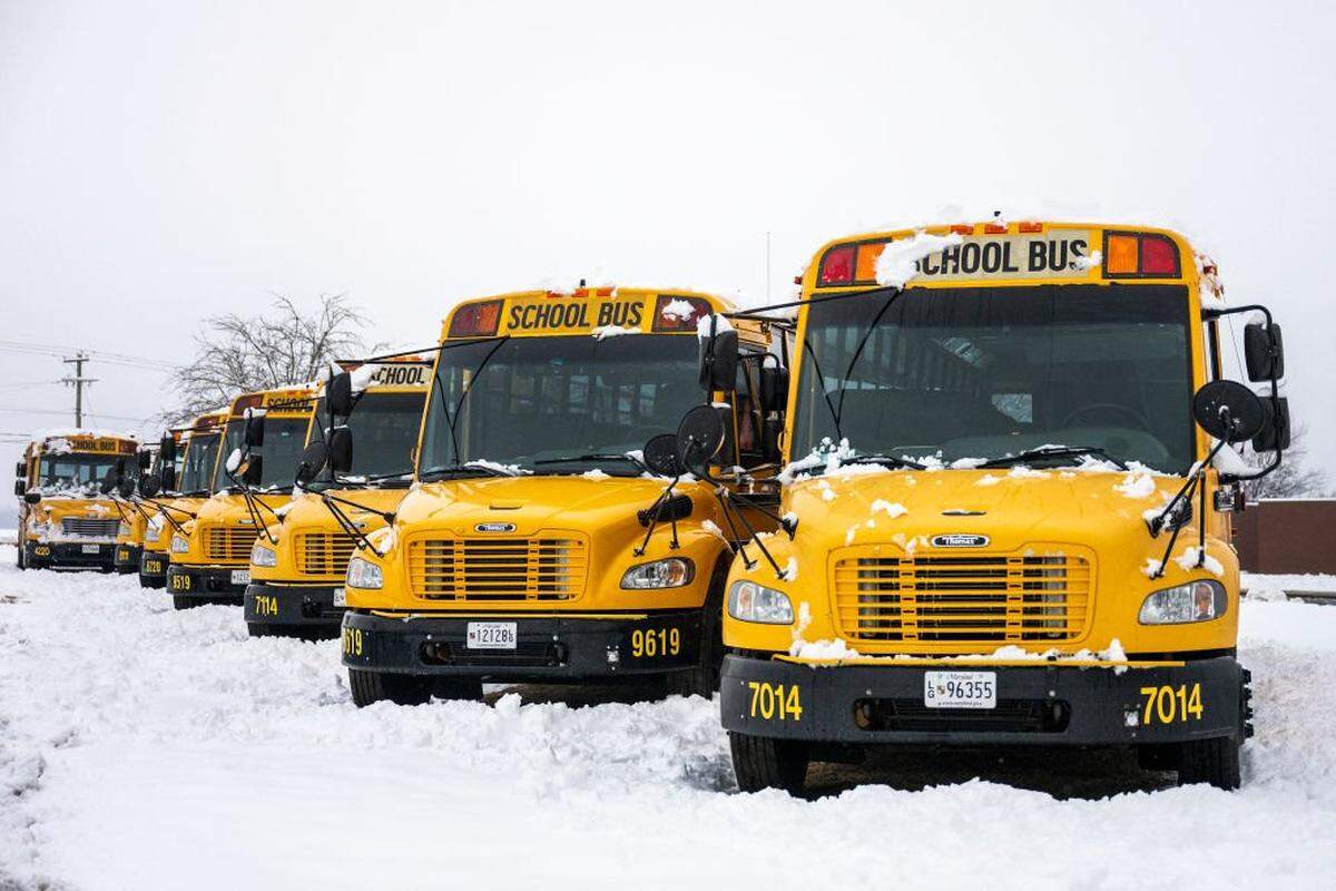 County school buses stand empty in a snow covered parking lot in Centreville, Maryland, on February 12, 2025, after a winter storm brought heavy snow across the state and region. (Photo by Jim WATSON / AFP) (Photo by JIM WATSON/AFP via Getty Images)