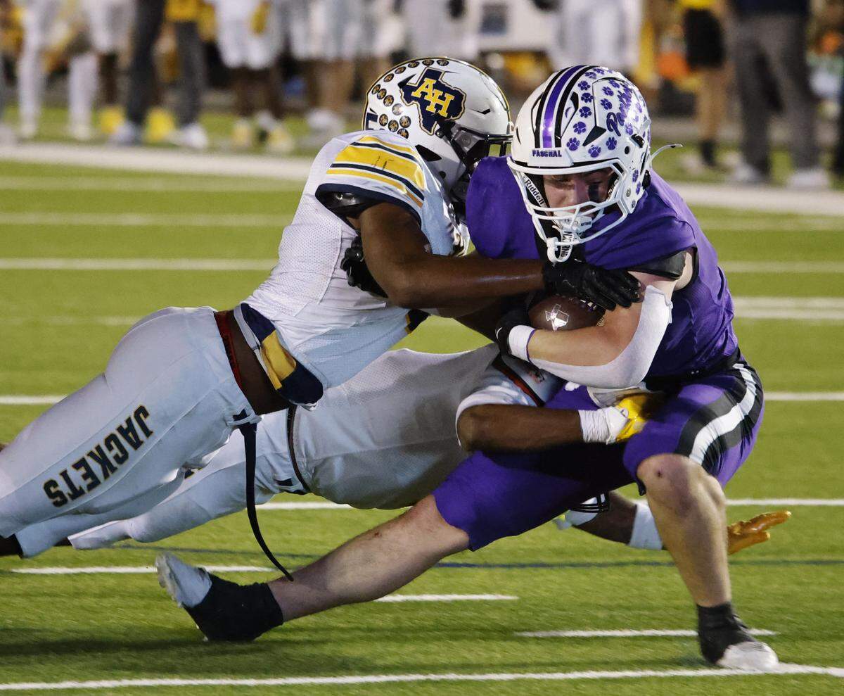 Paschal running back Truman Shelton (2) is brought down by Arlington Heights linebacker Kelle Johnson (5) during the first half of a UIL football game between Arlington Heights and Paschal at Farrington Field in Fort Worth, Texas, Friday Nov. 07, 2025.