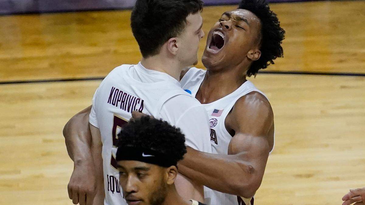 Florida State center Balsa Koprivica (5) gets a hug from teammate Scottie Barnes, right, after a dunk during the second half of a second-round game against Colorado in the NCAA college basketball tournament at Farmers Coliseum in Indianapolis, Monday, March 22, 2021. (AP Photo/Charles Rex Arbogast)