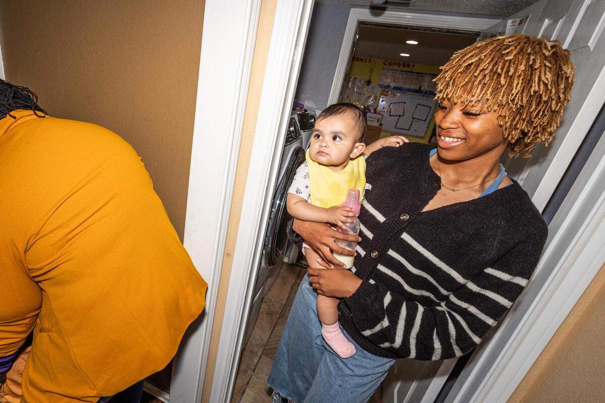 Child care center teacher Halle Chaney carries her infant student Natalia Arriago to the infant sleeping area in the evening at the Future Scholars’ Childcare and Transportation child care home in Grand Prairie on Thursday, March 14, 2024. Future Scholars’ is one of few programs in Tarrant County that provide 24/7 child care.