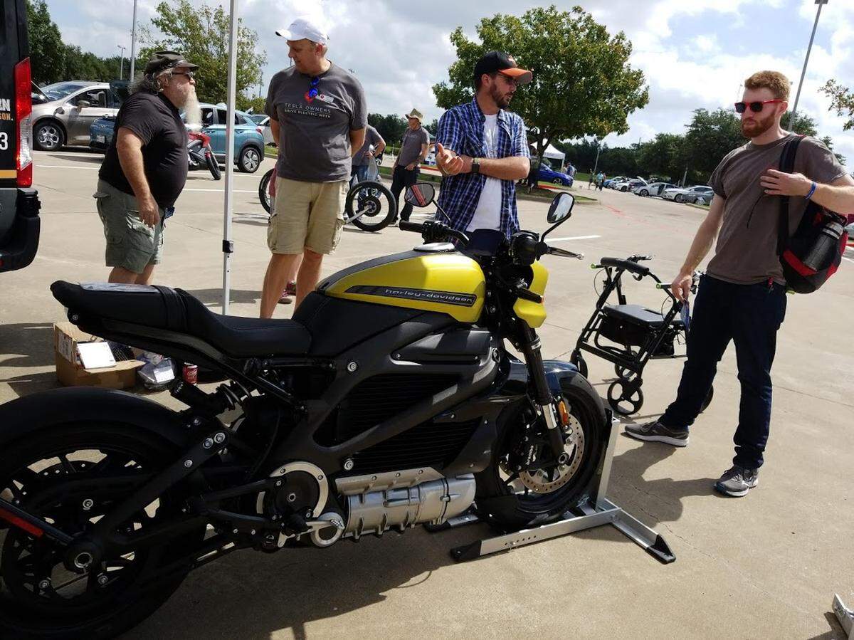 Jason Martin, riding academy instructor at Harley Davidson, (left) talks about the company’s new, all-electric Livewire motorcycle at the National Drive Electric Week event Saturday in Irving.