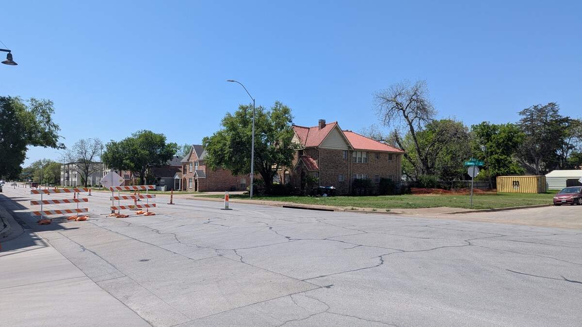 An empty lot on a wide residential street