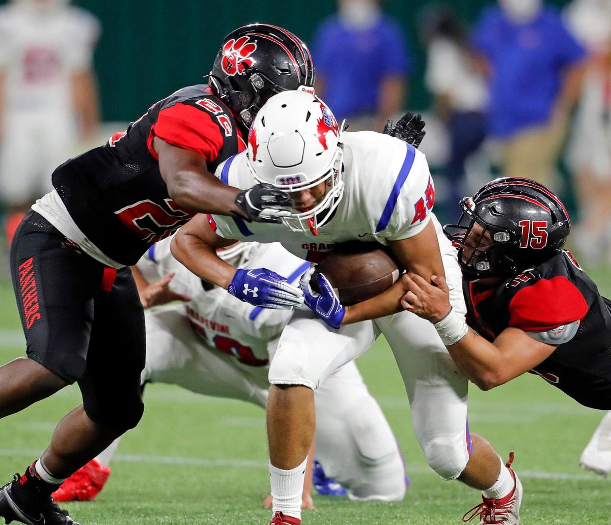 Colleyville Heritage corner back Michael Neves (24) and linebacker Chris Knight (15) bring down Grapevine tight end Matthew Debrei (45) during a high school football game at Globe Life Park in Arlington, Texas, Saturday, Sept. 26, 2020. Colleyville led 28-24 at the half. (Special to the Star-Telegram Bob Booth)