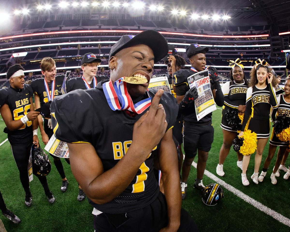 Timpson running back (7) JJ Garner bites his championship medal after the UIL Conference 2A Division I state championship football game at AT&T Stadium in Arlington, Texas, Wednesday, Dec. 13, 2023.
