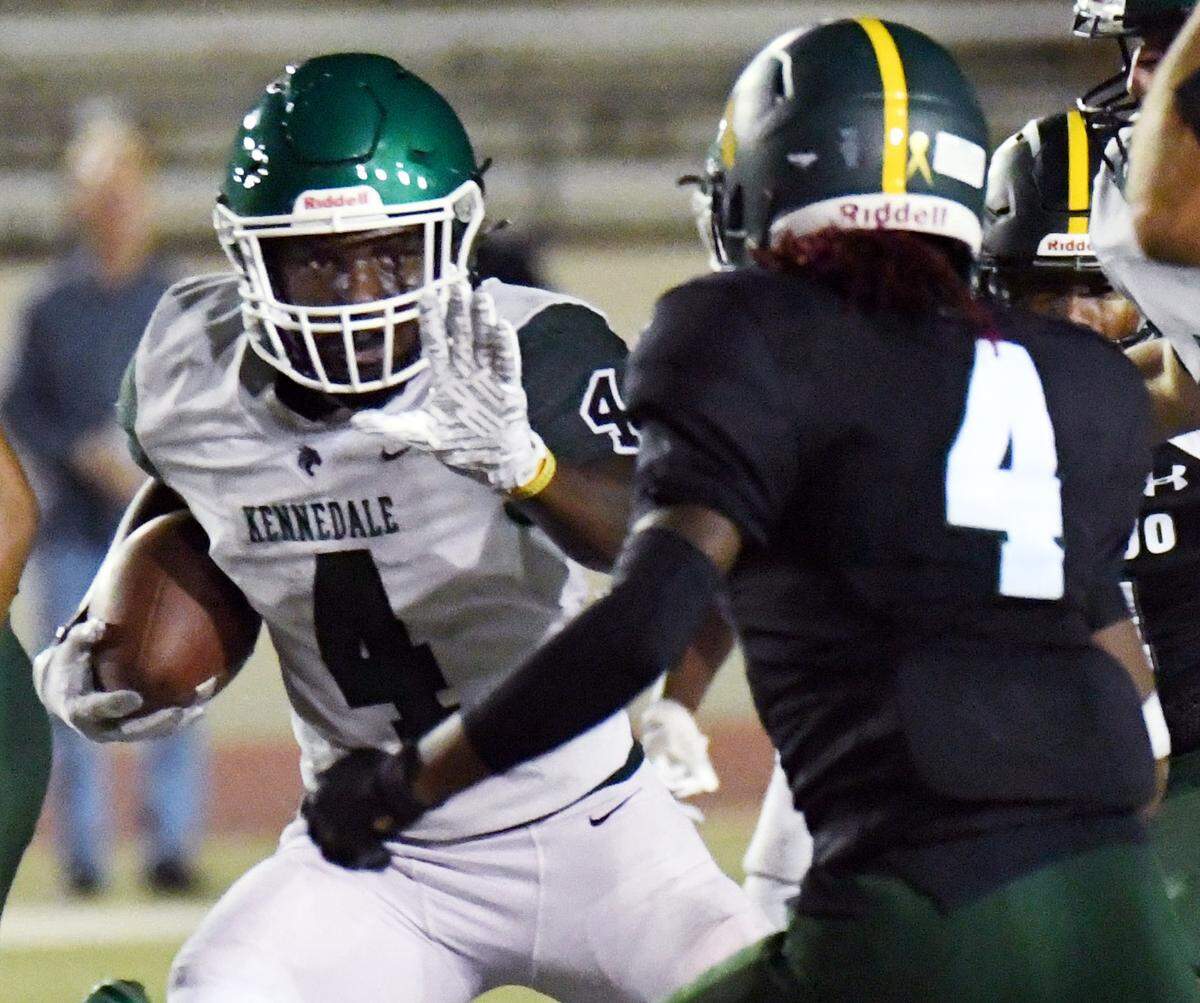 Kennedale’s EJ Higgins, left stiff arms Western Hills’s Kai’Juan Harper as he breaks out of the back-field for a first down in the second quarter of their District 6-4A Division 1 football game at Farrington Field in Fort Worth, Texas. Kennedale went on to win 40-14. Special/Bob Haynes