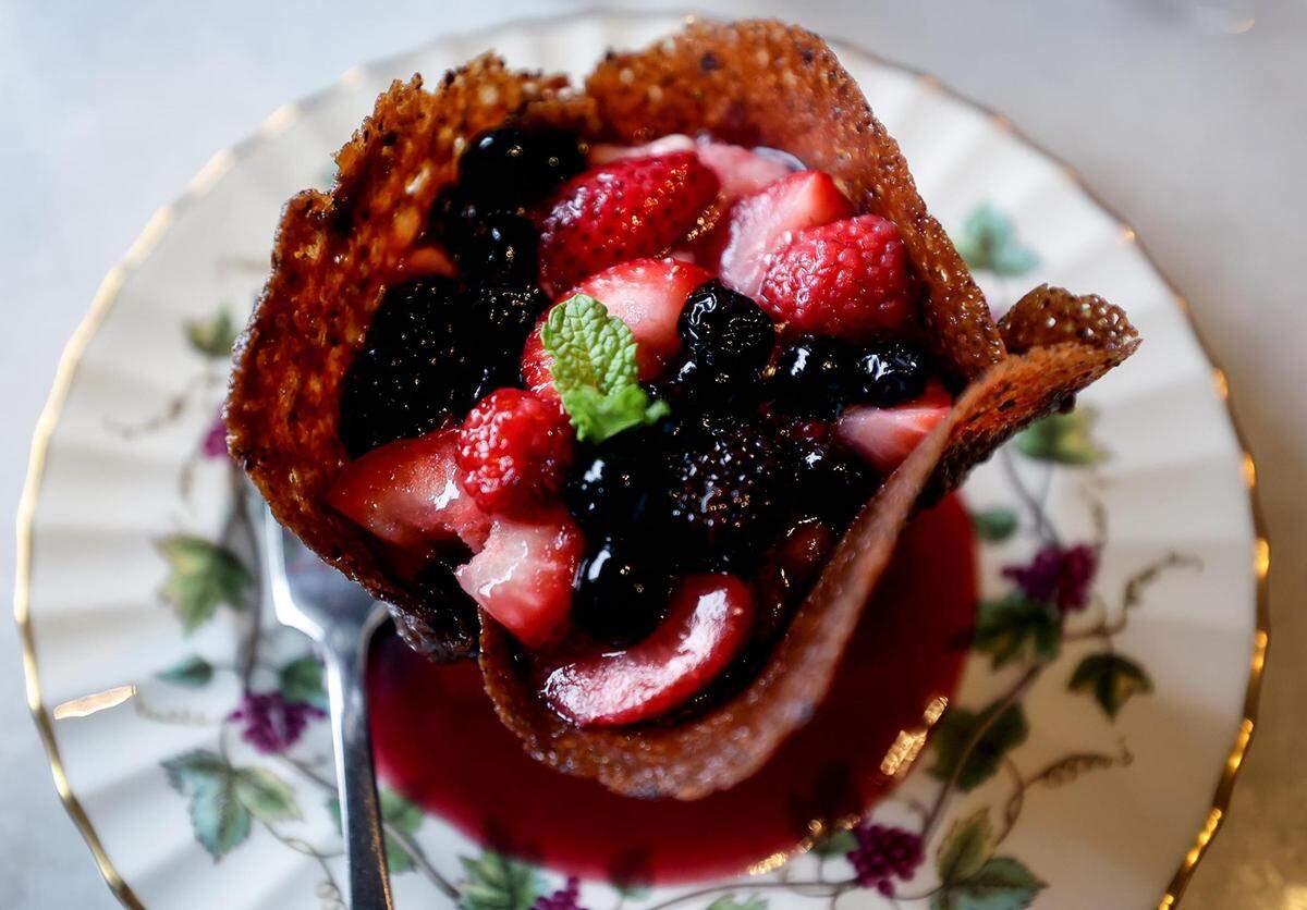 The tuile aux mures at Paris 7th in Fort Worth features berries warmed in raspberry liquor with fromage blanc in a crunch pistachio and coconut cup.