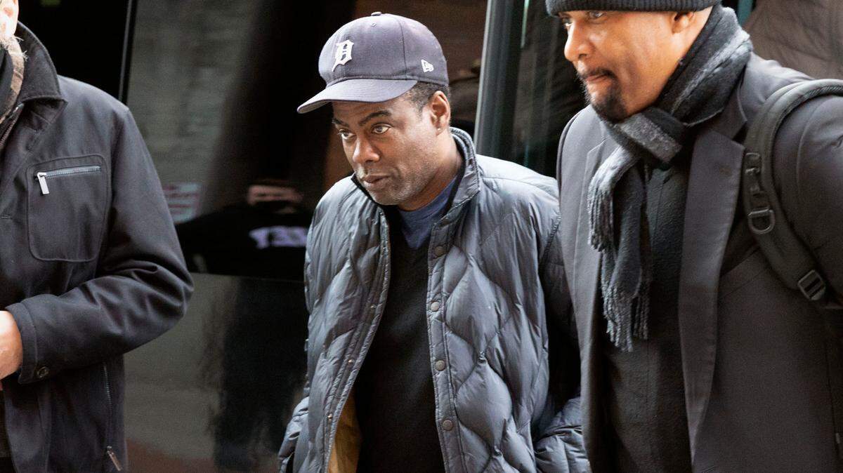 Chris Rock, center, arrives at the Wilbur Theatre in Boston Wednesday before a standup set, his first public appearance since he was slapped by Will Smith during the Oscars telecast on Sunday.