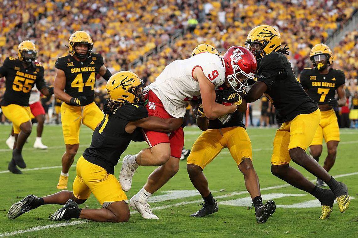 TEMPE, ARIZONA - OCTOBER 25: Tanner Koziol #9 of the Houston Cougars makes a reception against Keith Abney II #1 and Myles Rowser #4 of the Arizona State Sun Devils during the first quarter of the NCAAF game at Mountain America Stadium on October 25, 2025 in Tempe, Arizona. (Photo by Christian Petersen/Getty Images)