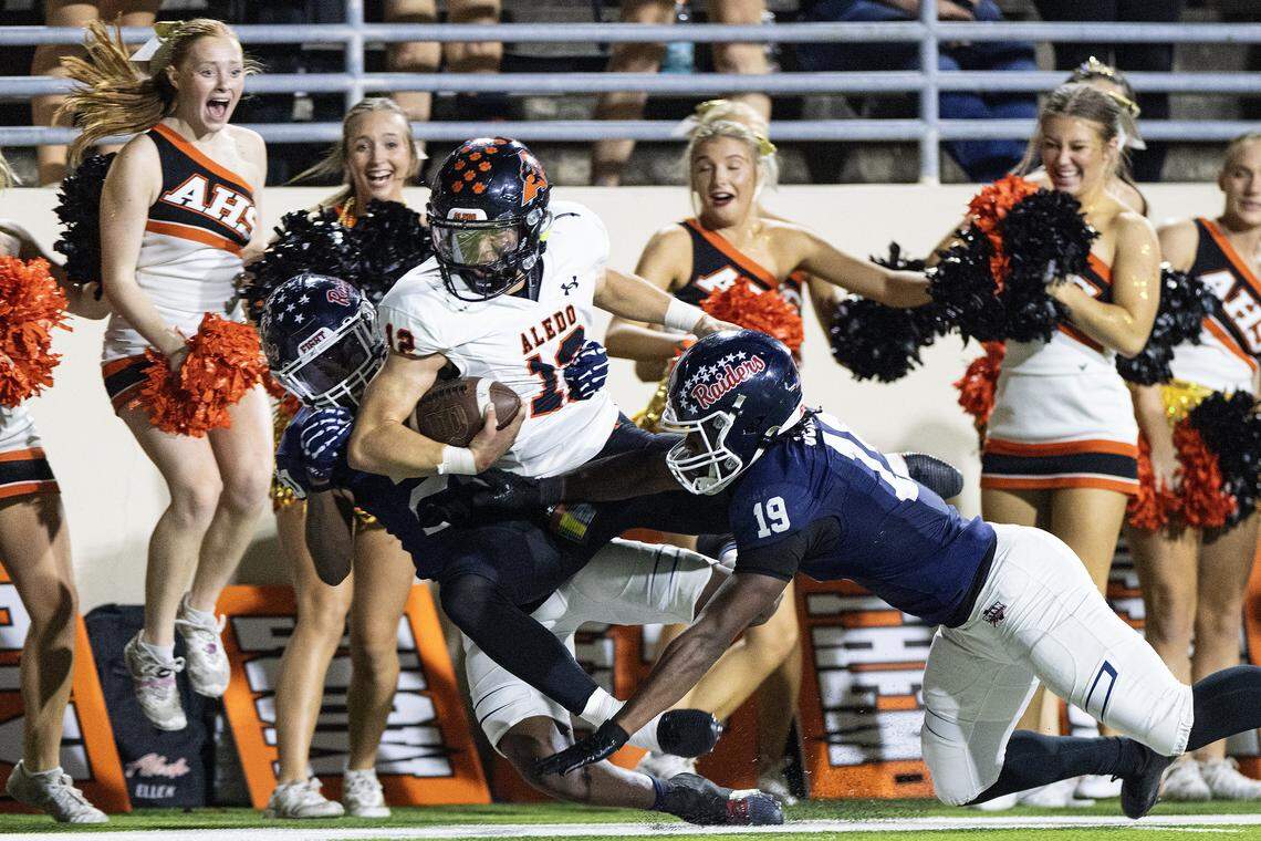 Aledo quarterback Lincoln Tubbs (12) gets tackled out of bounds into the cheerleaders in the second half of a high school football game between the Aledo Bearcats and the Denton Ryan Raiders at C.H. Collins Athletic Complex in Denton on Friday, Oct. 3, 2025. 