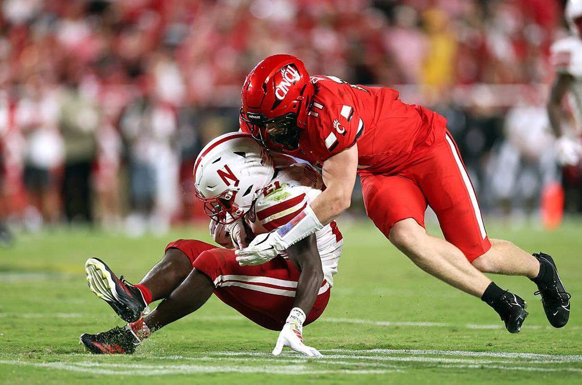 KANSAS CITY, MISSOURI - AUGUST 28: Running back Emmett Johnson #21 of the Nebraska Cornhuskers is tackled by linebacker Jake Golday #11 of the Cincinnati Bearcats during the game at Arrowhead Stadium on Aug. 28, 2025 in Kansas City, Missouri. (Photo by Jamie Squire/Getty Images)