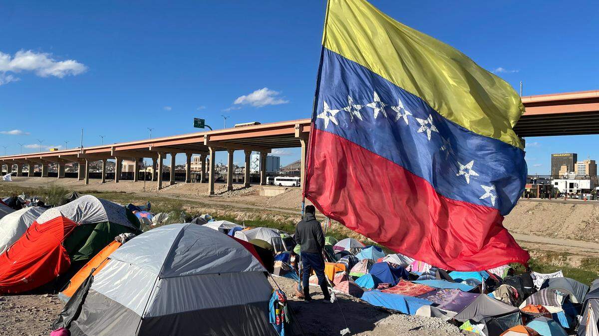 The Venezuelan flag waves in the wind at a temporary migrant camp on the southern banks of the Rio Grande in Juarez, Mexico, in November 2022.