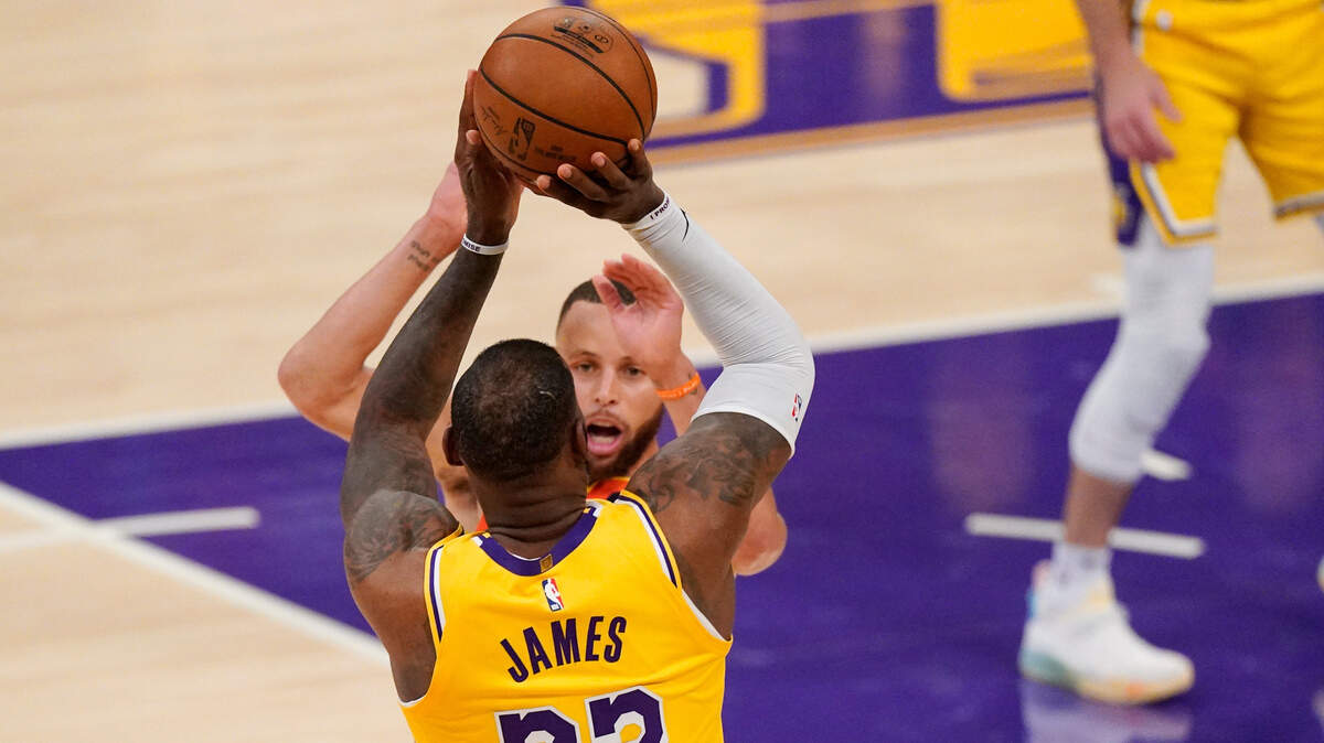 Los Angeles Lakers forward LeBron James shoots a game-clinching 3-pointer as the shot clock expired to lead the Lakers over the Golden State Warriors in a play-in game Wednesday night in Los Angeles.