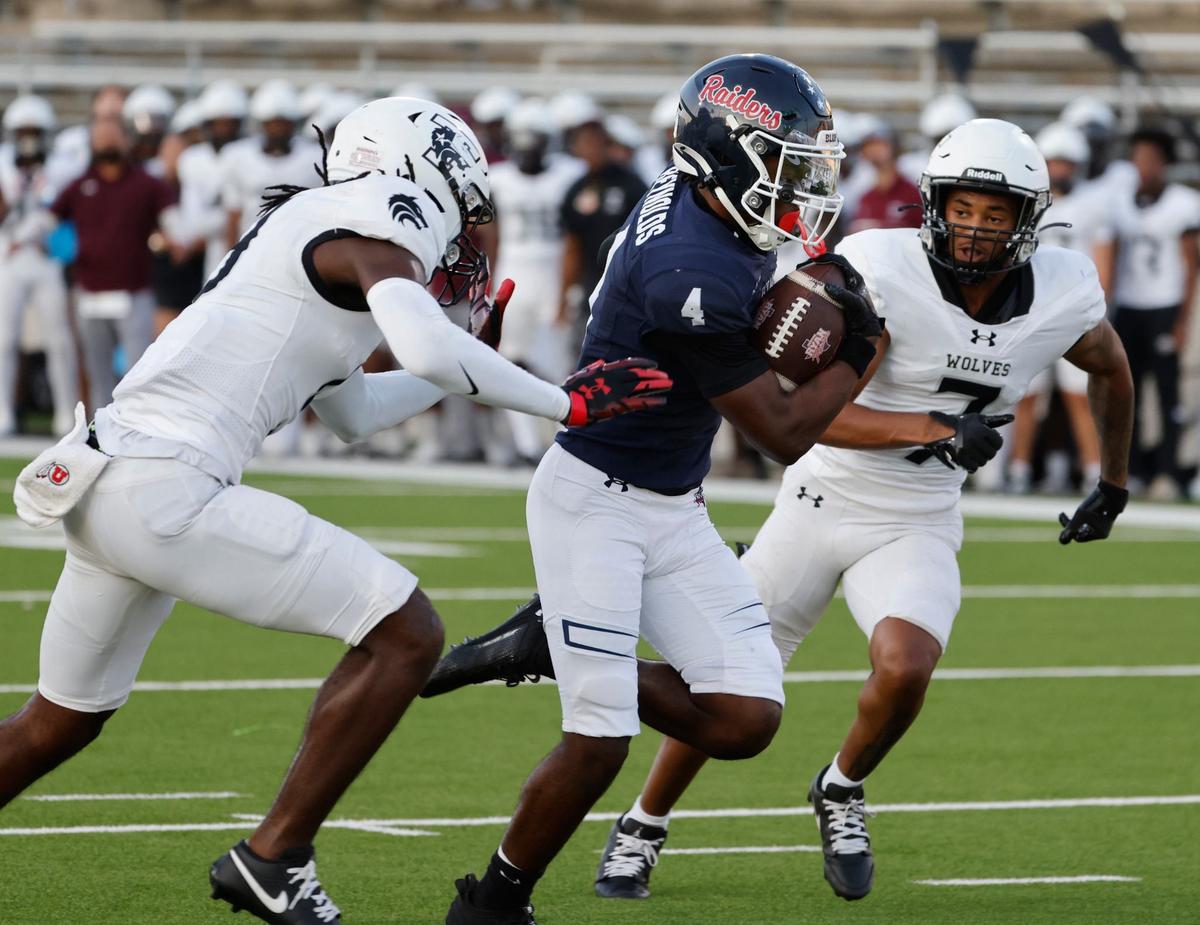 Denton Ryan running back Tre’Vaughn Reynolds (4) splits the defense of Timberview safety Nathan Tilmon (9) and defensive back Landon Blair (7) during a UIL football game at C.H. Collins Activity Complex in Denton, Texas, Thursday, Sept. 05, 2024.